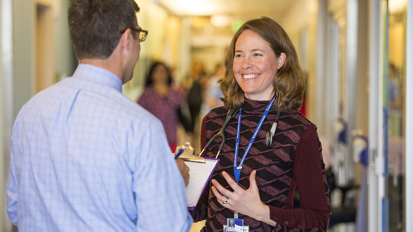 Two cardiology doctors talk in a hallway