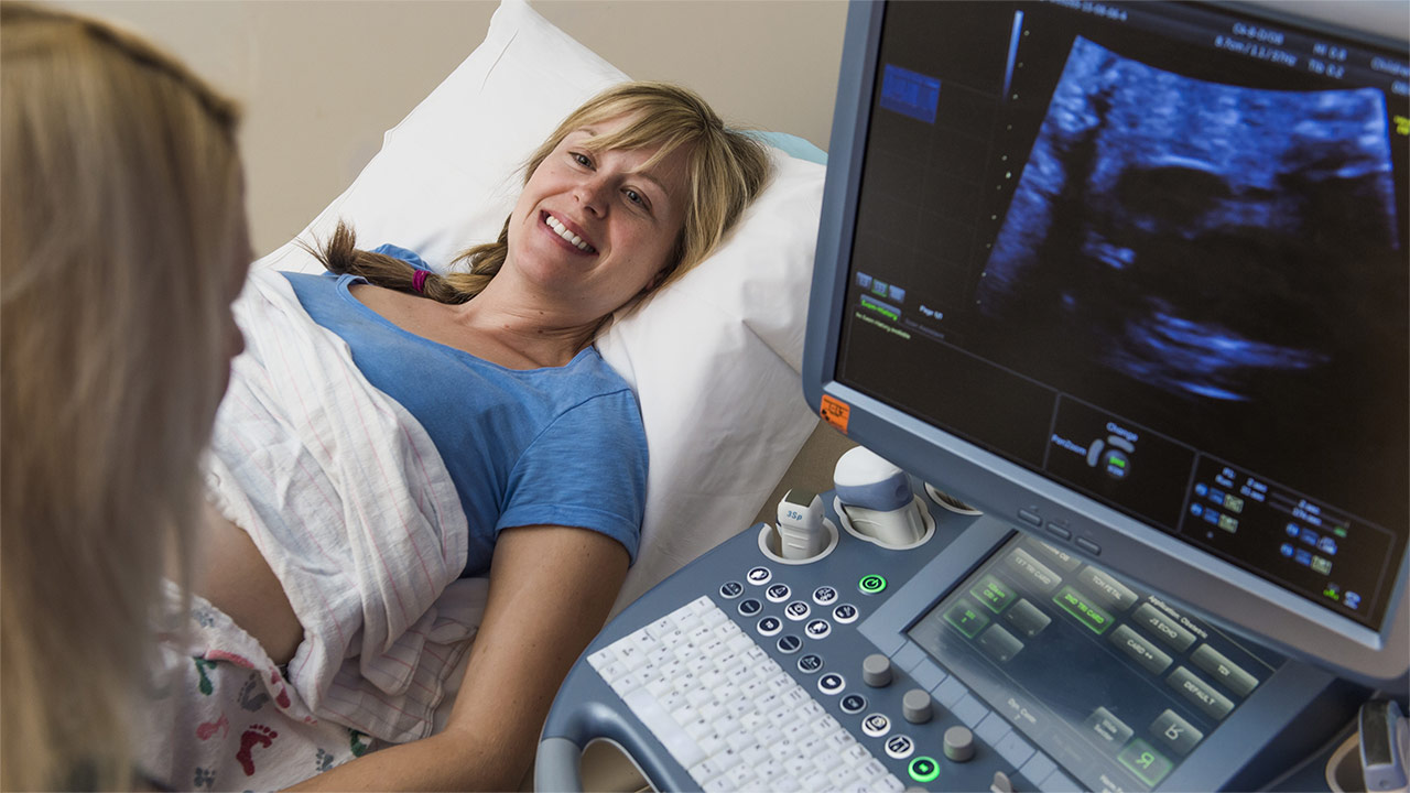 A woman performs an ultrasound on a fetal cardiology patient.