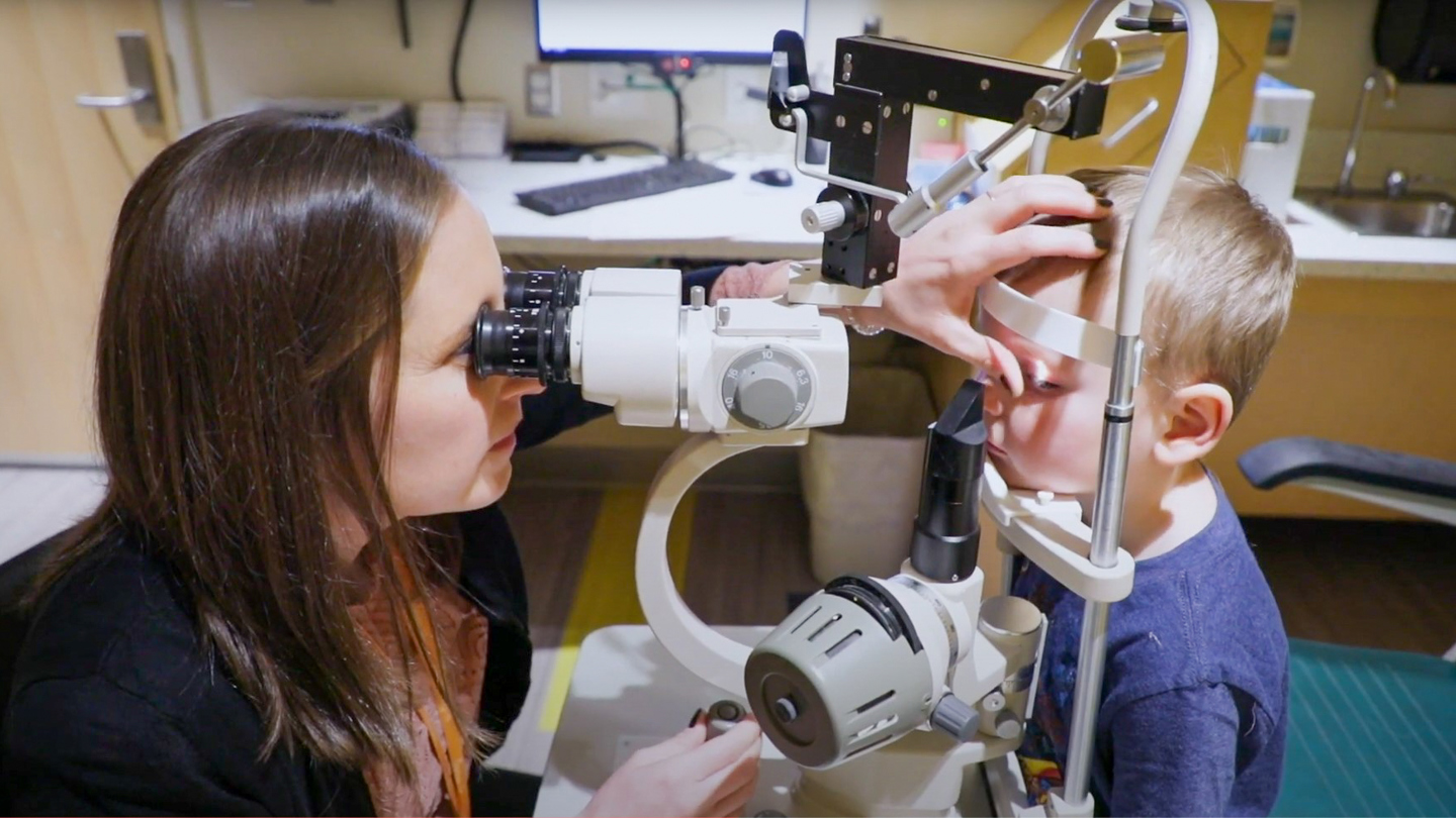 Dr. Emily McCourt, Chair of Pediatric Ophthalmology at Children's Hospital Colorado, performs an eye exam on young boy.