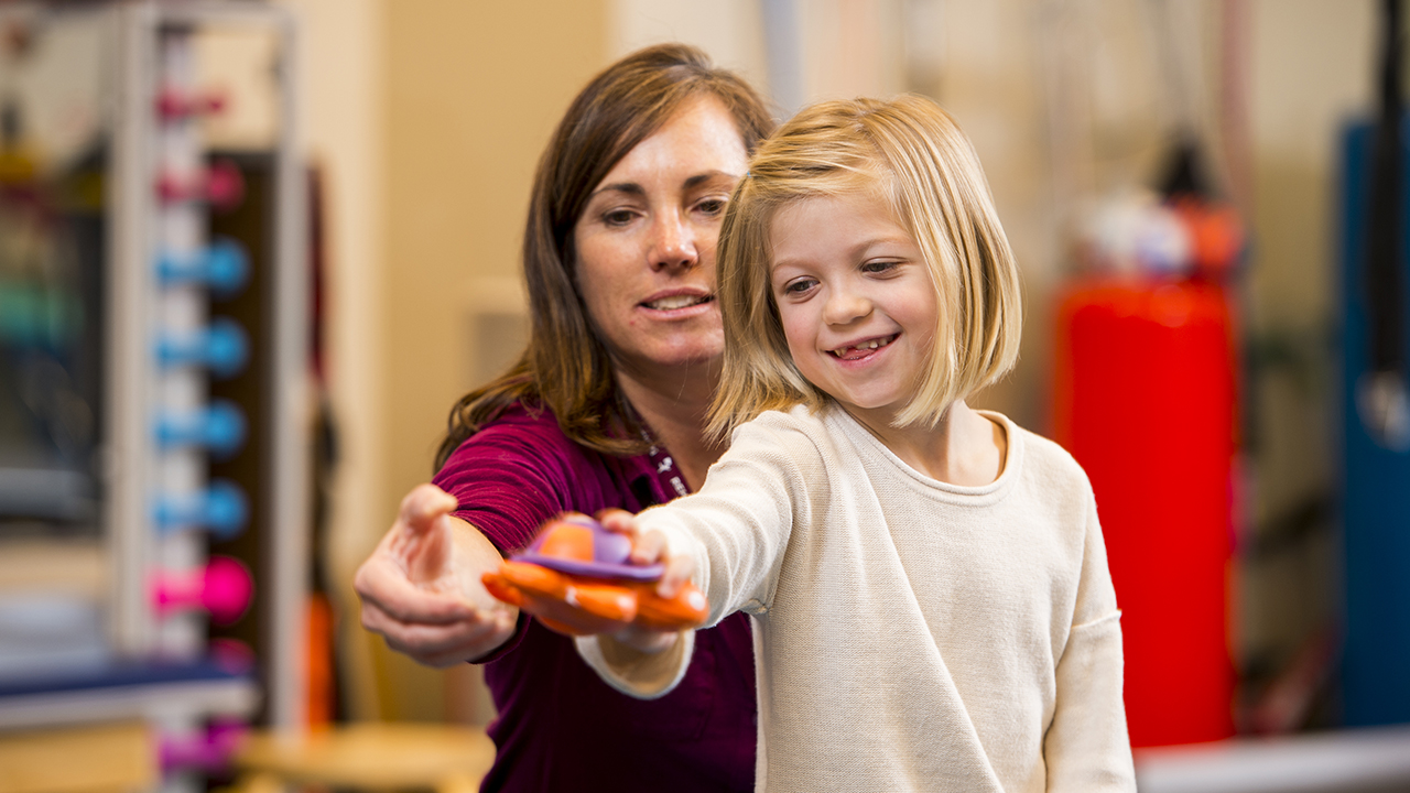 A physician helps a girl during inpatient rehabilitation